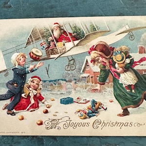 Carte postale de Noël ancienne Père Noël dans un avion biplan faisant tomber des cadeaux Carte postale Winsch gaufrée 1913