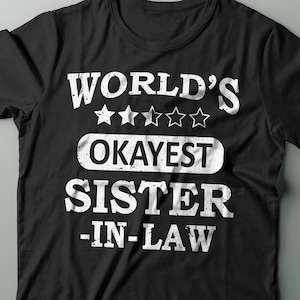 May include: Black t-shirt with white text that reads "World's Okayest Sister-In-Law" with five white stars above the text.