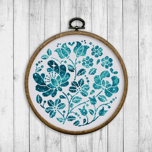 May include: A teal blue floral embroidery pattern in a round wooden embroidery hoop.