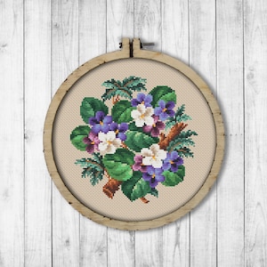 May include: A cross-stitch embroidery hoop with a floral design featuring purple and white flowers with green leaves.