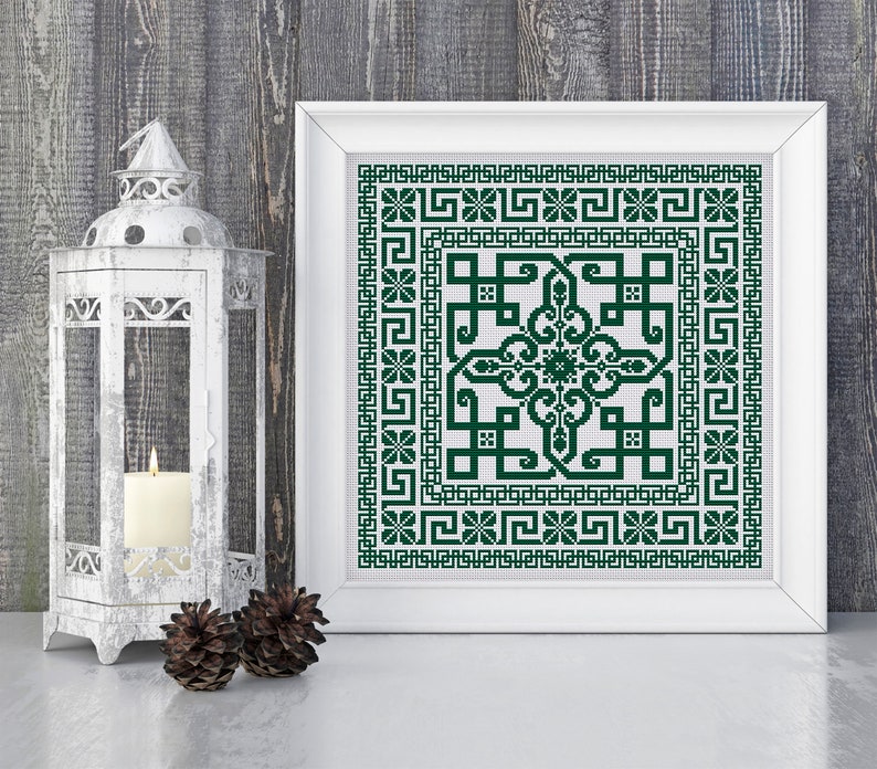May include: A framed cross-stitch design with a green geometric pattern on a white background. The design features a central square with intricate details and a border of repeating motifs.