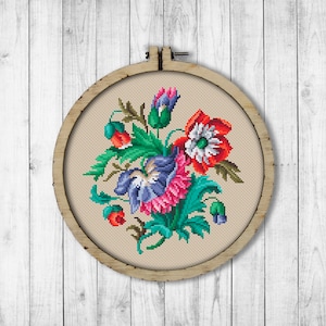 May include: A framed embroidery hoop with a colorful floral design. The flowers are red, pink, blue, and green. The embroidery is on a beige fabric.