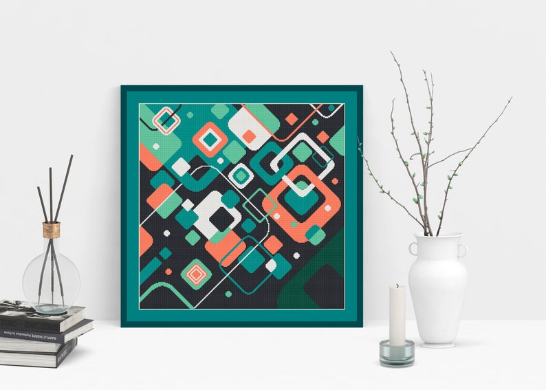 Pode incluir: Uma impress&atilde;o geom&eacute;trica abstrata emoldurada com formas azul-esverdeadas, verdes, brancas e laranja sobre um fundo preto. A moldura &eacute; azul-esverdeada.