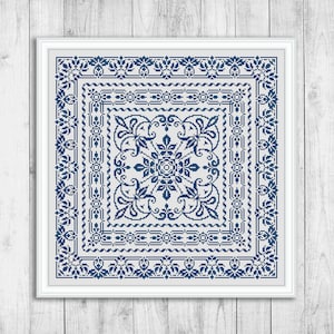 Könnte beinhalten: Ein blaues und weißes Kreuzstichmuster mit einem floralen Design in der Mitte und einem Rand aus sich wiederholenden Mustern.