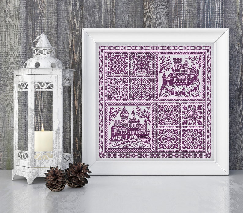 May include: A framed purple and white cross-stitch design featuring a castle and various geometric patterns.