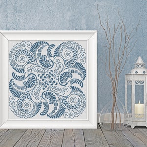 Op de afbeelding: Een wit frame met een blauw en wit bloemenontwerp op een witte achtergrond. Het frame staat op een houten vloer met een vaas en een lantaarn op de achtergrond.