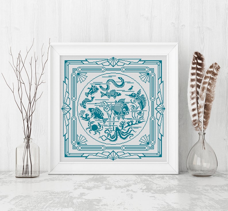 May include: A framed cross-stitch design featuring a teal blue circle with various stylized fish and sea creatures, surrounded by a decorative teal blue frame.