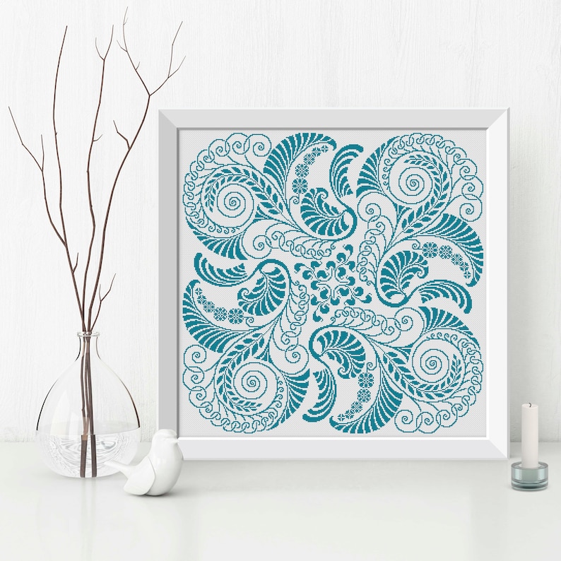 Op de afbeelding: Een tealblauw bloemenontwerp met ingewikkelde swirls en bladeren, ingelijst in een wit frame.