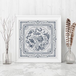 May include: A framed cross-stitch design featuring a circle of various sea creatures, including fish, a crab, an octopus, and a seahorse. The design is surrounded by a geometric border in a light blue color.