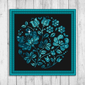 May include: A teal blue floral design with white accents on a black background. The design is framed in a teal blue frame.
