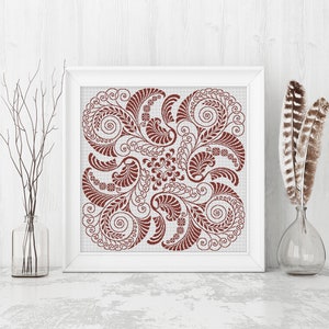Op de afbeelding: Een vierkante ingelijste print met een bruin bloemenontwerp op een witte achtergrond. Het ontwerp is symmetrisch en bevat ingewikkelde swirls en bladeren.