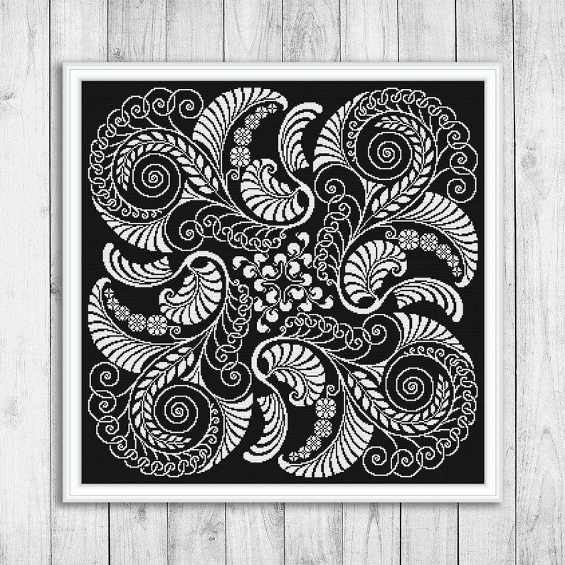 Op de afbeelding: Zwart-witte kruissteekpatroon met een symmetrisch ontwerp van gestileerde bladeren en spiralen.
