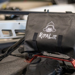 May include: A black, water-resistant bag with a white logo that says "RIPALIP" and a fish graphic. The bag is attached to a red metal bracket.
