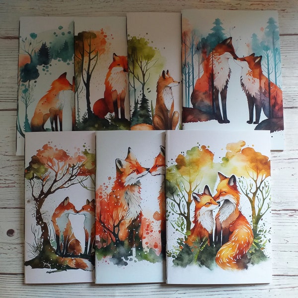 Puede incluir: Conjunto de 8 acuarelas que representan zorros en varias poses y entornos. Las pinturas están sobre papel blanco con un fondo azul claro. Los zorros están representados en una variedad de colores, incluyendo naranja, rojo, marrón y blanco.