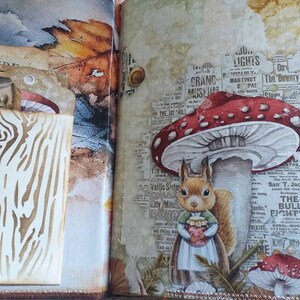 K&ouml;nnte beinhalten: Eine skurrile Scrapbook-Seite mit einer Illustration eines Eichh&ouml;rnchens, das einen Topf unter einem rot-wei&szlig;en Pilz h&auml;lt. Die Seite enth&auml;lt Vintage-Zeitungsausschnitte, ein Blatt und ein Holzschild mit Baumrindenmuster.