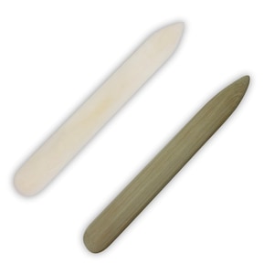 Könnte beinhalten: Zwei Holzwerkzeuge zum Lederhandwerk. Eines ist hellbraun und das andere ist dunkelbraun.