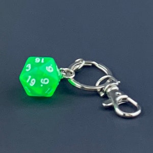 May include: A green, translucent, 20-sided die with white numbers on each face, attached to a silver key chain with a clasp.