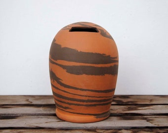 Piggy bank made from red and black earthenware clay