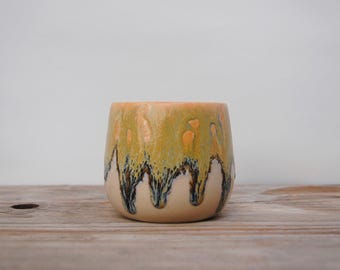 Cup with drippy textured orange/blue glaze. 250ml