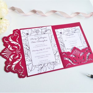 May include: Burgundy red laser cut wedding invitation with a floral design and the text "Stacey Bullington & Peter Cunningham" and "Saturday, July 20, 2019".