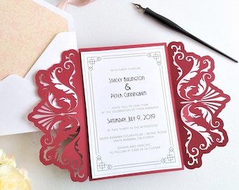 May include: Red laser-cut wedding invitation with a white inner card. The invitation features a decorative floral design and the text "WITH GREAT PLEASURE STACEY BULLINGTON & PETER CUNNINGHAM INVITE YOU TO JOIN THEM AT THE CELEBRATION OF THEIR MARRIAGE SATURDAY, JULY 9, 2019 AT TWO THIRTY IN THE AFTERNOON SANTA BARBARA COURTHOUSE - MURAL ROOM SANTA BARBARA, CALIFORNIA DINNER AND DANCING TO FOLLOW AT CASA DE LA GUERRA"