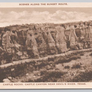 May include: Sepia-toned vintage postcard featuring a landscape of Castle Rocks, Castle Canyon near Devil's River, Texas. The image shows a rock formation with the text "SCENES ALONG THE SUNSET ROUTE." The postcard is a historical travel souvenir.