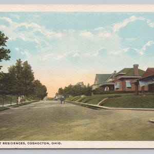 Könnte beinhalten: Eine alte Postkarte, die eine Straße mit Häusern in Coshocton, Ohio, zeigt. Die Postkarte trägt den Titel "Main Street Residences, Coshocton, Ohio".