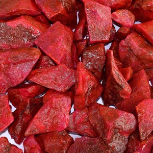 Peut inclure: Un ensemble de pierres précieuses de rubis brutes, d'un rouge profond et intense. Les pierres ont une surface texturée et irrégulière. L'image présente des rubis bruts, probablement fraîchement extraits.