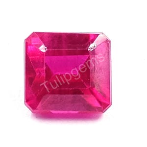 Op de afbeelding: Een vierkant geslepen, gefacetteerde, felroze edelsteen met de tekst "Tulipgems" op het oppervlak. De edelsteen heeft een heldere, reflecterende kwaliteit en de facetten creëren een spel van licht en schaduw.