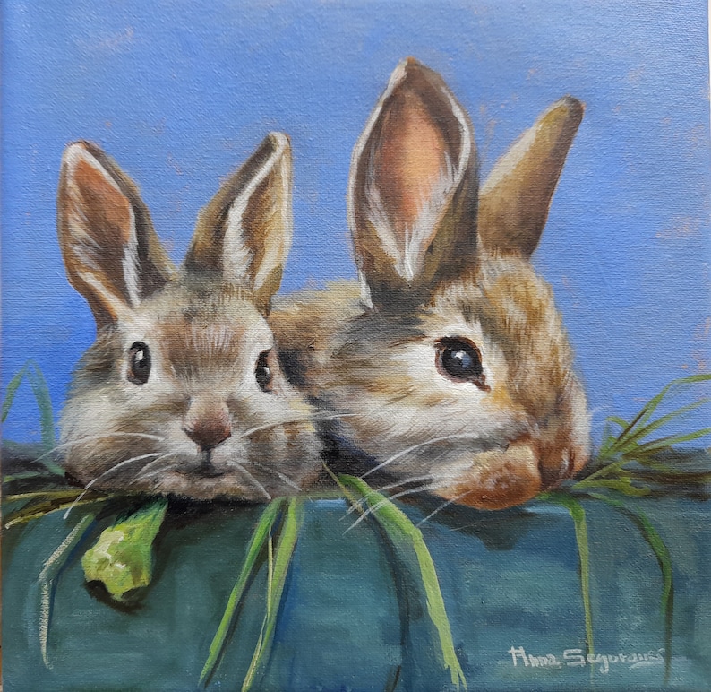May include: An oil painting of two brown rabbits with long ears and dark eyes, peeking over a teal surface. Green grass and a light blue background complete the scene. The artist's signature is visible in the bottom right corner.