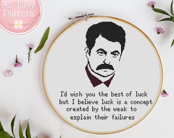 May include: A black and white cross-stitch pattern featuring a portrait of a man with a mustache and the quote "I'd wish you the best of luck but I believe luck is a concept created by the weak to explain their failures."