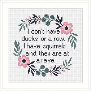 May include: Cross-stitch pattern with a floral wreath and the text "I don't have ducks or a row. I have squirrels and they are at a rave."