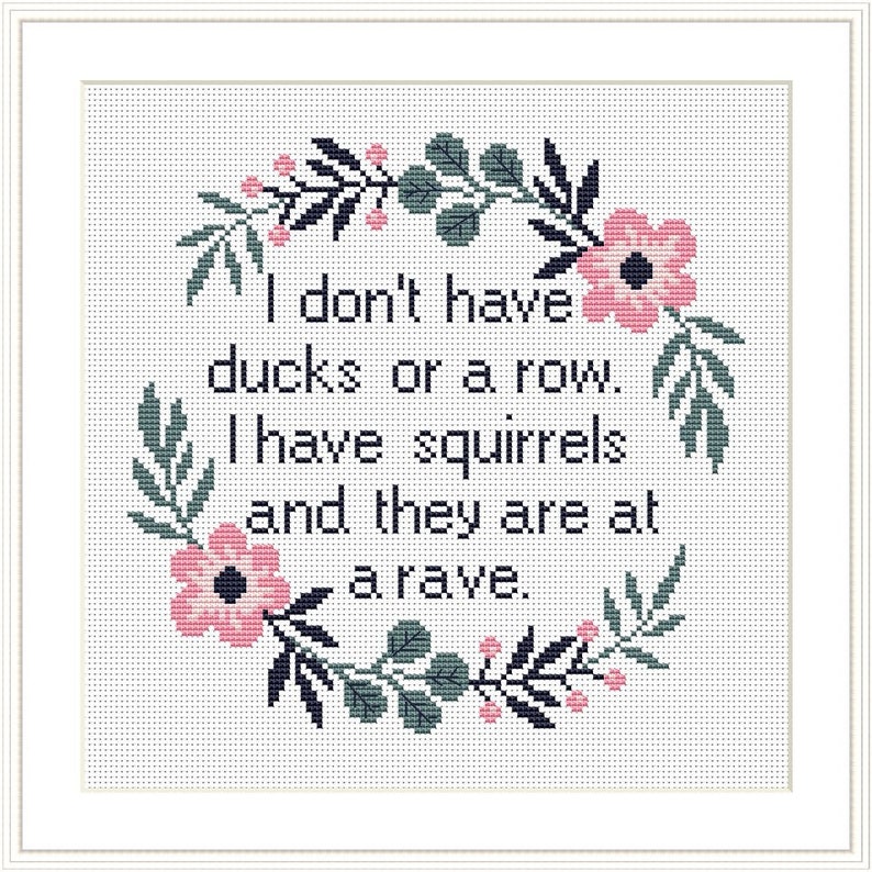 May include: Cross-stitch pattern with a floral wreath and the text "I don't have ducks or a row. I have squirrels and they are at a rave."