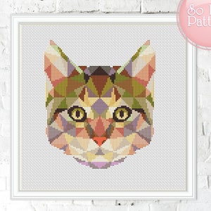 May include: A framed cross-stitch pattern of a cat's face, created with geometric shapes in shades of green, brown, yellow, and purple. The cat has large yellow eyes and a pink nose. The text "So Easy Pattern" is in the upper right corner.