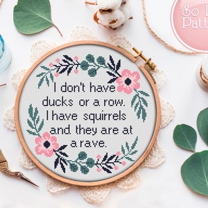 May include: Cross stitch embroidery hoop with a floral design and the text "I don't have ducks or a row. I have squirrels and they are at a rave."