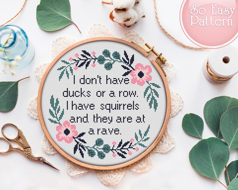 May include: Cross stitch embroidery hoop with a floral design and the text "I don't have ducks or a row. I have squirrels and they are at a rave."