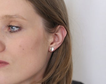 Pendientes minimalistas curvos en plata de ley para un look moderno y elegante.