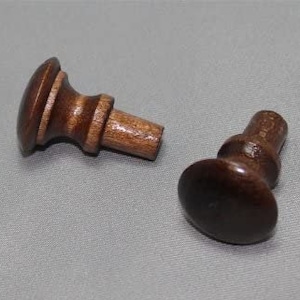 May include: Two wooden knobs with a dark brown finish. One knob has a round top and the other has a slightly pointed top.