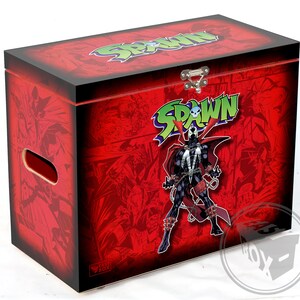 Puede incluir: Caja de madera roja con tapa con bisagras y asa. La caja está decorada con un personaje de cómic, Spawn, y la palabra "Spawn" en letras verdes. La caja está etiquetada como "Fast Box".
