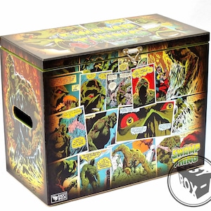 Puede incluir: Una caja de almacenamiento de madera con un diseño de cómic de Swamp Thing. La caja está decorada con imágenes del personaje de Swamp Thing de varios paneles de cómics. La caja tiene una tapa con bisagras y una manija en el lateral. El texto "Swamp Thing" está impreso en el lateral de la caja.