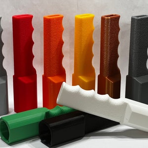 May include: Assortment of 3D printed handles in various colours, including grey, red, orange, yellow, brown, green, black, and white. The handles are designed with a textured grip and are approximately 25 cm long.