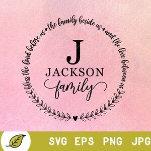 May include: A black and white circular design with a wreath of leaves around the edge. The text "Bless the food before us the family beside us and the love between us" is written around the circle. In the centre of the circle is the letter "J" and the text "JACKSON family".