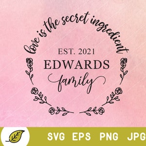 May include: A pink watercolour background with a black circle containing the text "Love is the secret ingredient" above the text "EST. 2021 EDWARDS family" with a floral wreath around the circle.