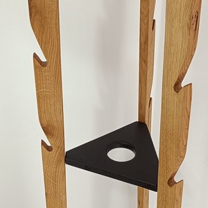 Puede incluir: Un perchero de madera con un estante triangular y un recorte redondo. El perchero tiene un acabado de madera natural y está hecho de madera maciza.