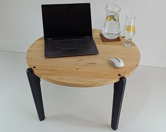 以下が含まれることがあります： 黒い脚のついた丸い木製のテーブルに、ラップトップ、ワイヤレスマウス、レモンのスライスが入ったグラス、レモンのスライスが入ったピッチャーが木製のコースターの上に置かれています