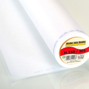 Könnte beinhalten: Eine weiße Rolle  thermoklebbarer Einlage mit der Aufschrift "Vlieseline Vilene Fliselina H 250/305" mit einem roten und weißen Etikett. Das Etikett enthält den Produktcode, die Größe und die Materialzusammensetzung: 60% PES, 40% Zellstoff.