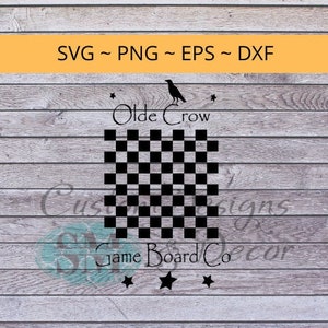 Puede incluir: Un tablero de juego de ajedrez blanco y negro con el texto "Olde Crow Game Board Co." y una silueta de cuervo negro sobre el texto.