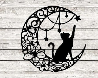 May include: Black silhouette of a cat reaching for a star on a crescent moon with floral details.