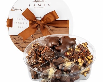 May include: A round gift box with a brown ribbon and a tag reading HAPPY FATHER'S DAY, containing a clear plastic tray divided into four sections filled with assorted dark chocolate-covered nuts, pretzels, and bear-shaped chocolate candies.
