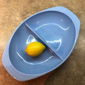 May include: A divided serving dish made of light blue ceramic with a single lemon in one of the sections.